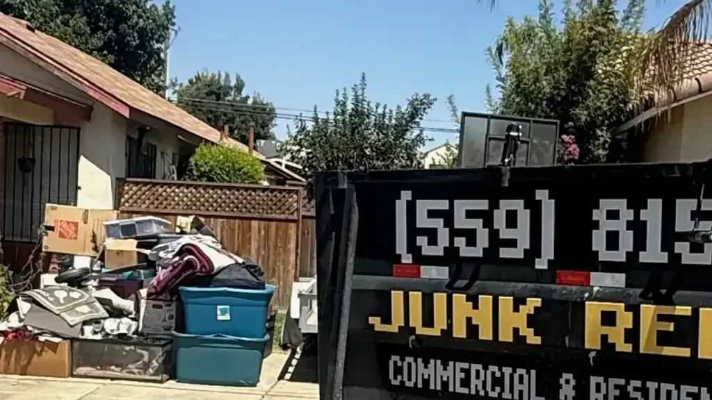 A curbside pile of household junk beside the Trash N Dash trailer
