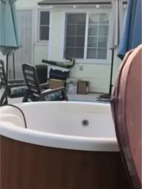 A brown hot tub on a backyard lawn