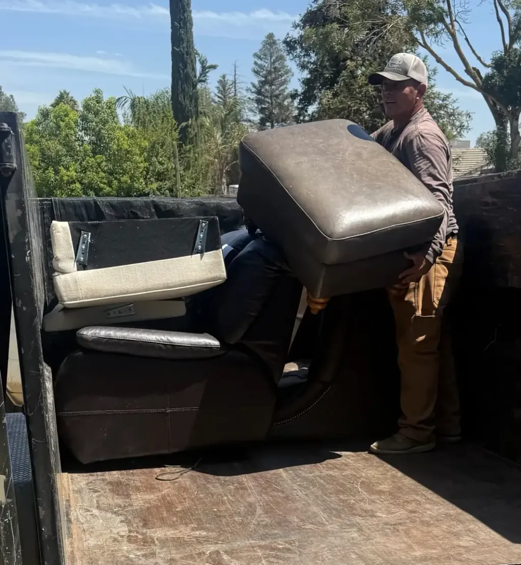 A crew member carrying a sofa section into the trailer